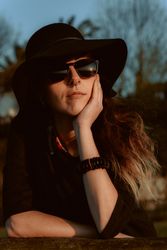 Dreaming stylish woman in sunglasses and hat