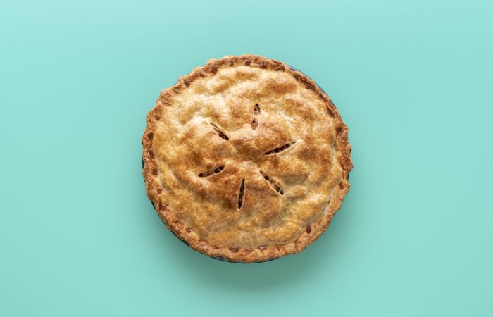 Apple pie above view, isolated on a green background