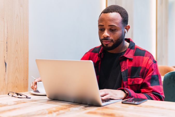 Black man working on laptop in cafe