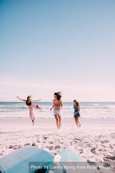 Group of women standing in motion in the sand at the beach y0vzo0