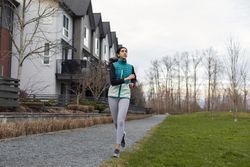 Young female running outdoors on a path.