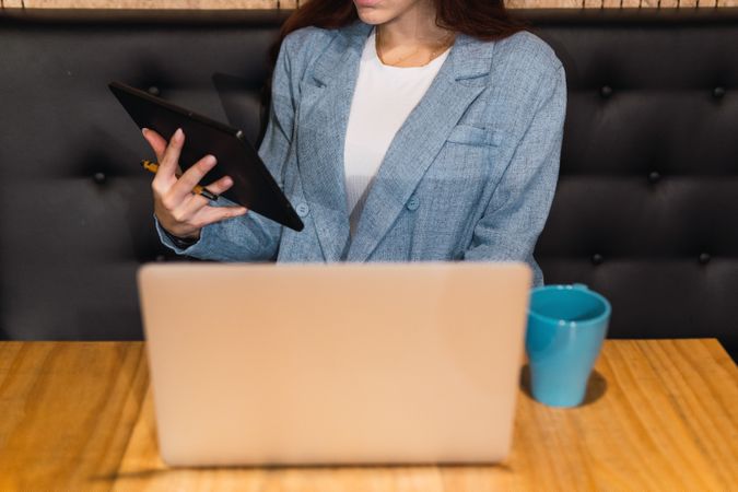 Anonymous businesswoman using tablet in restaurant