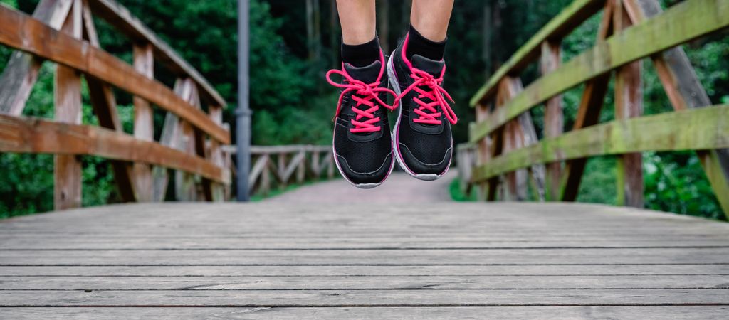 Athlete woman feet jumping outdoors