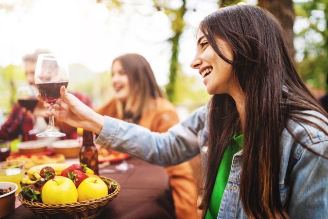 Friends toasting with wine at an outdoor picnic