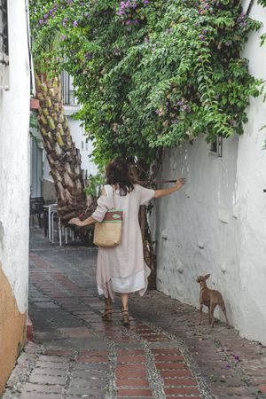 Woman walking downstairs with dog on narrow street