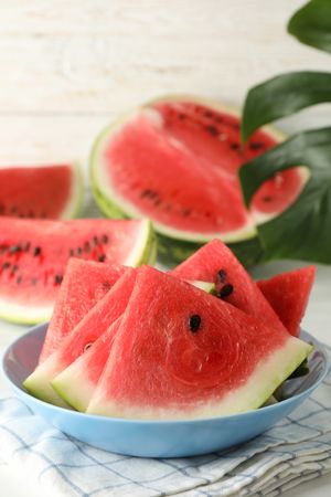 Composition with plate of fresh watermelon on blank wooden background