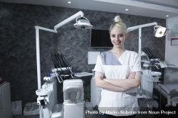 Smiling dentist with her arms crossed at work 0VMlNb
