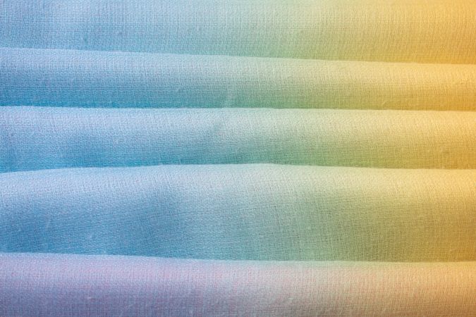 Gradient colorful folded fabric background texture. blue yellow and green.