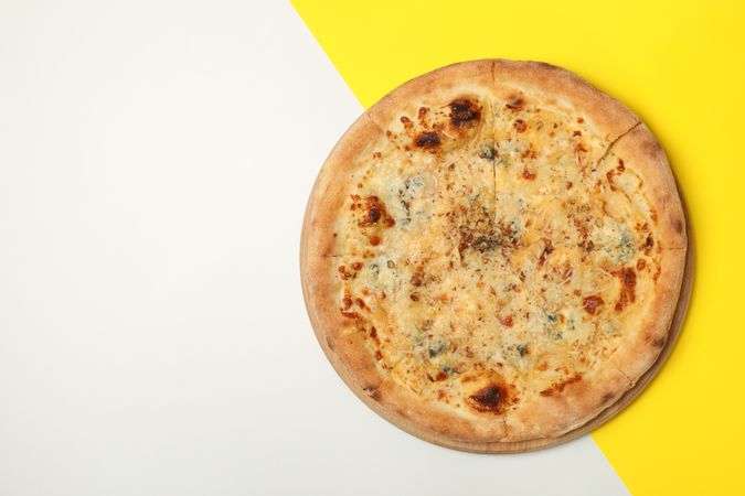 Cheese pizza on two tone background, top view