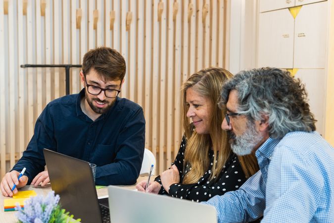 Cheerful colleagues working together on project in office