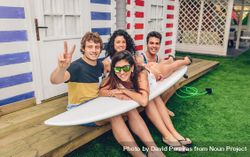 Young friends with woman siting on top of surfboard 4jVVPv