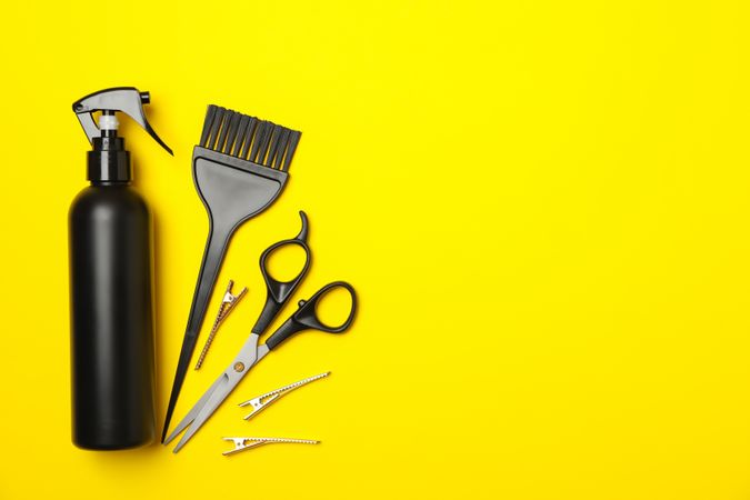 Composition with hairdresser accessories on yellow background, space for text