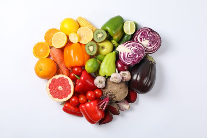 Heart laid out of vegetables and fruits on plain background, copy space