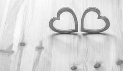 Two gray hearts on wooden table