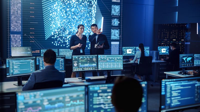 Diverse Team Collaborates in a Futuristic Control Room, Analyzing Real-time Data on Multiple Screens to Enhance Cybersecurity and Optimize Network Performance