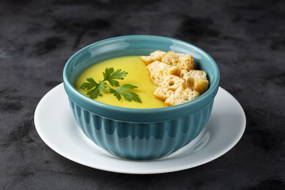 Bowl with onion soup and croutons on the table.