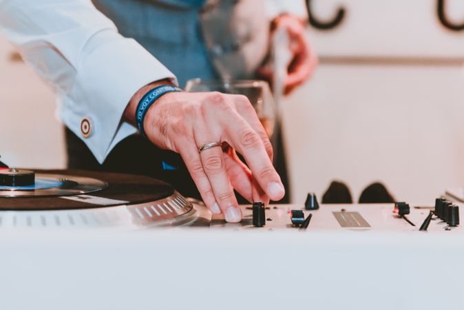 Man using music equalizer near glass of drink