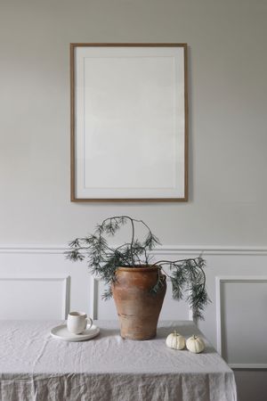 Wintry composition with blank wooden picture frame mockup hanging on beige wall