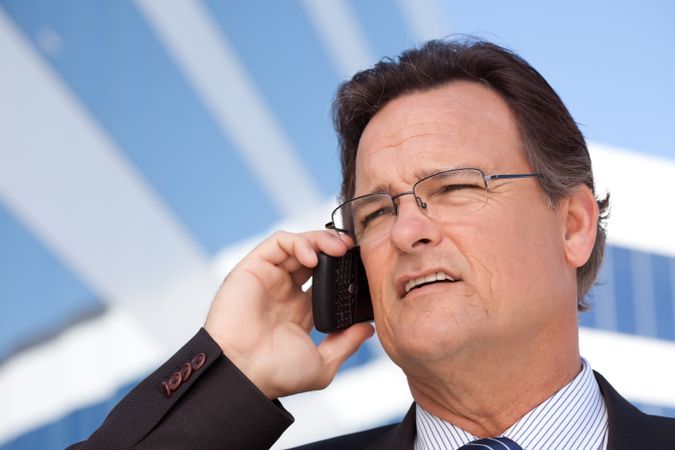 Businessman Smiles as He Talks on His Cell Phone