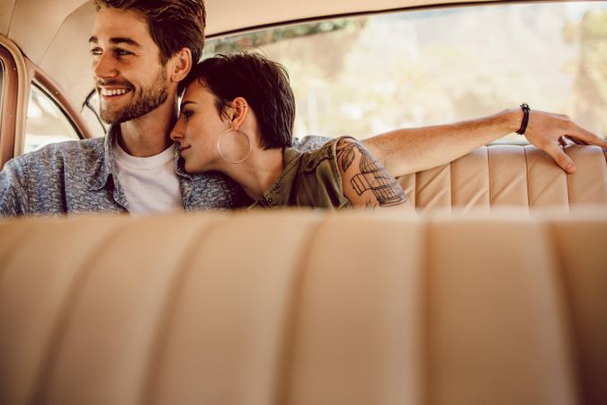 Couple snuggling in back seat of vintage car
