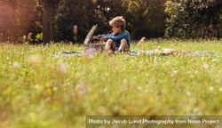 Small boy with basket on a picnic in the garden 48krj5