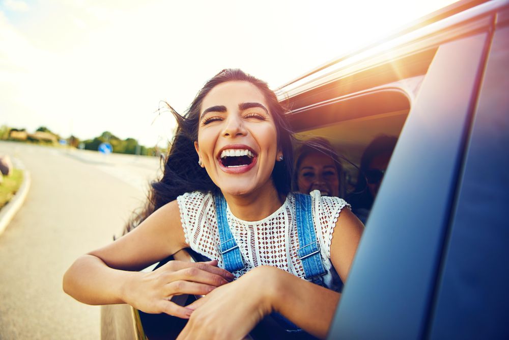 Laughing female half outside of car window