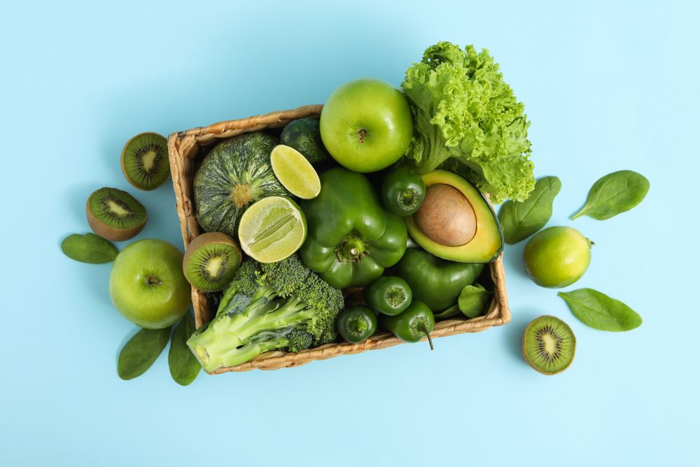 Basket with vegetable and fruits on blue background