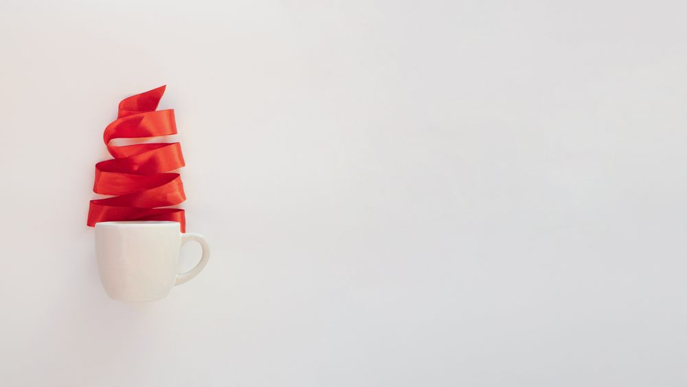 Red Christmas tree ribbon coming out of mug, copy space