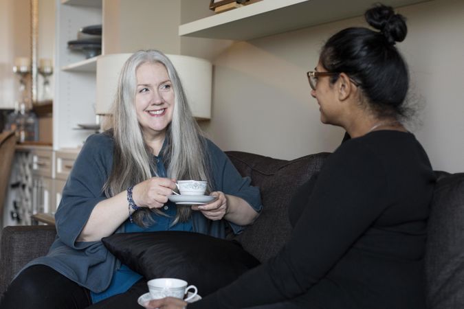 Two women having a conversation while sitting on a couch