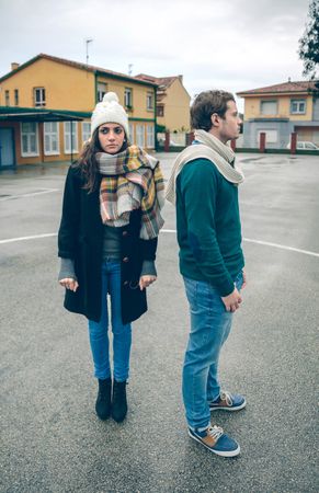 Man and woman standing away from each other in circle in sports court