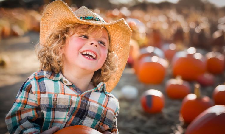 Cute Young Boy Wearing Cowboy Hat at Pumpkin Patch Farm.