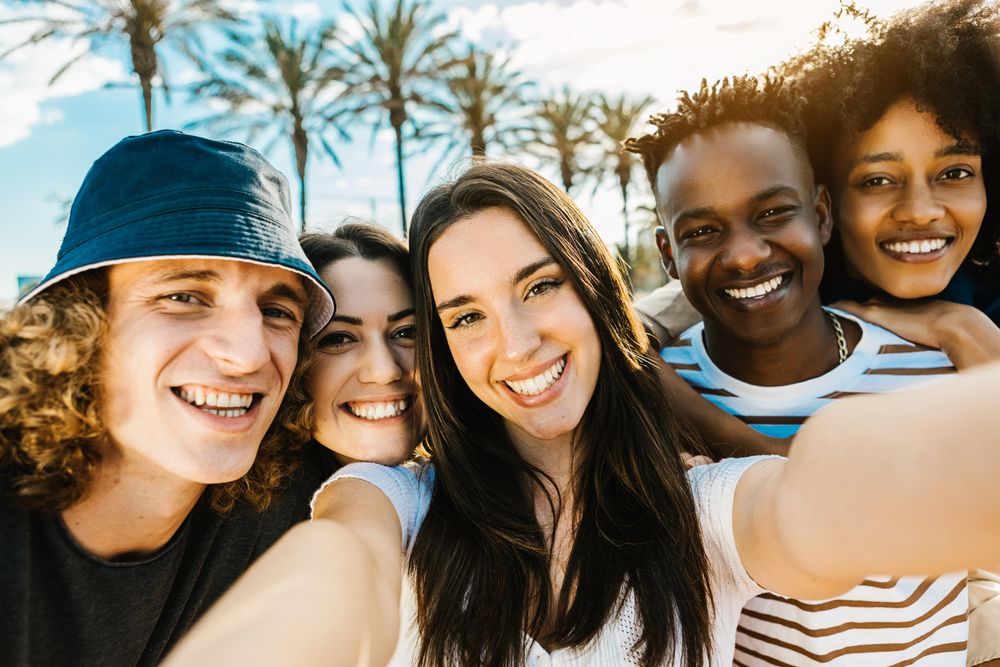 Young multiracial friends laughing and smiling while looking at camera