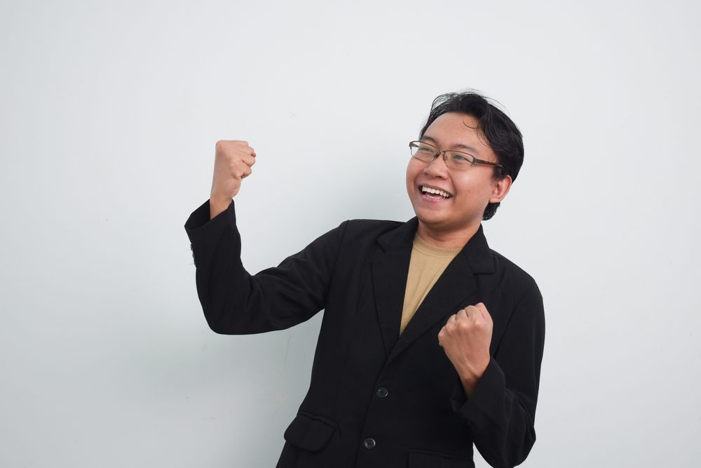 Happy businessman with hands up in glory