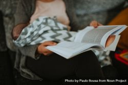 Women reads a book while breast feeding bD6ZA5