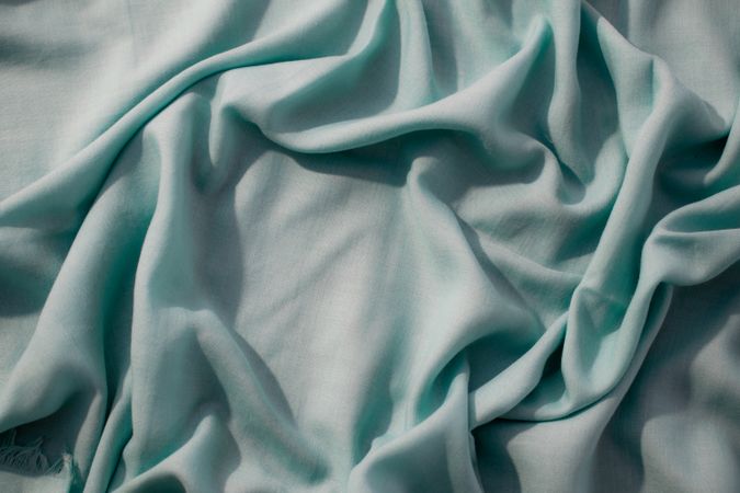Nude green fabric wavy crumpled background texture with copy space.