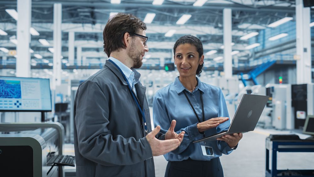 Colleagues talking in store over computer