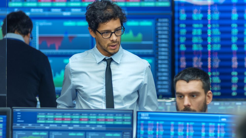 Stock Trader Inspects Others Work and Chat with Other.