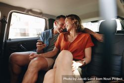 Couple in rear seat of car talking and smiling 0y2dO5