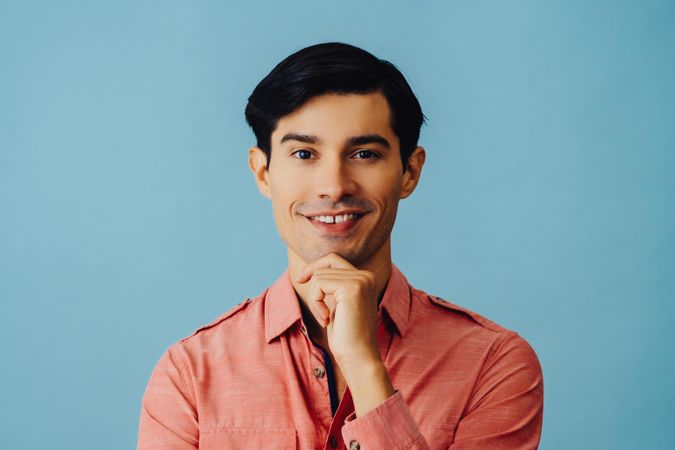 Portrait of curious Hispanic male smiling while looking at camera