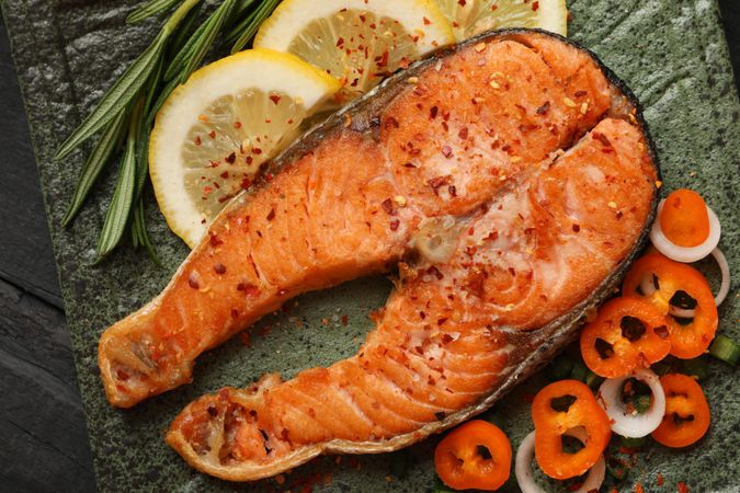 Composition with tasty grilled salmon on wooden background, close up