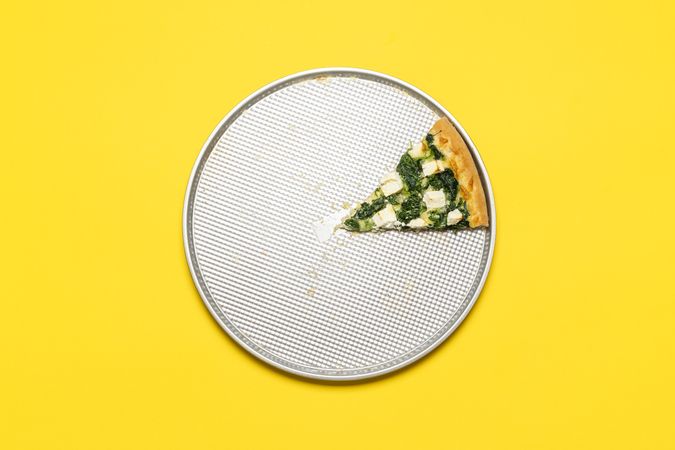Slice of vegetarian pizza on a tray, top view on a yellow background