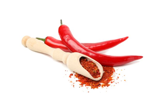 Scoop with spice and chilli peppers isolated on blank background