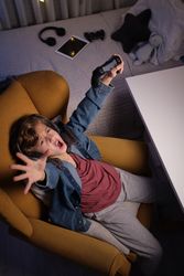 Joyful preteen boy rejoicing victory in videogame