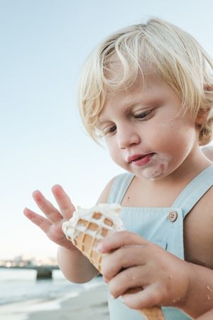 Cute boy eating ice cream on beach