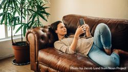 Woman relaxing at home and using her mobile phone 4Ampm4