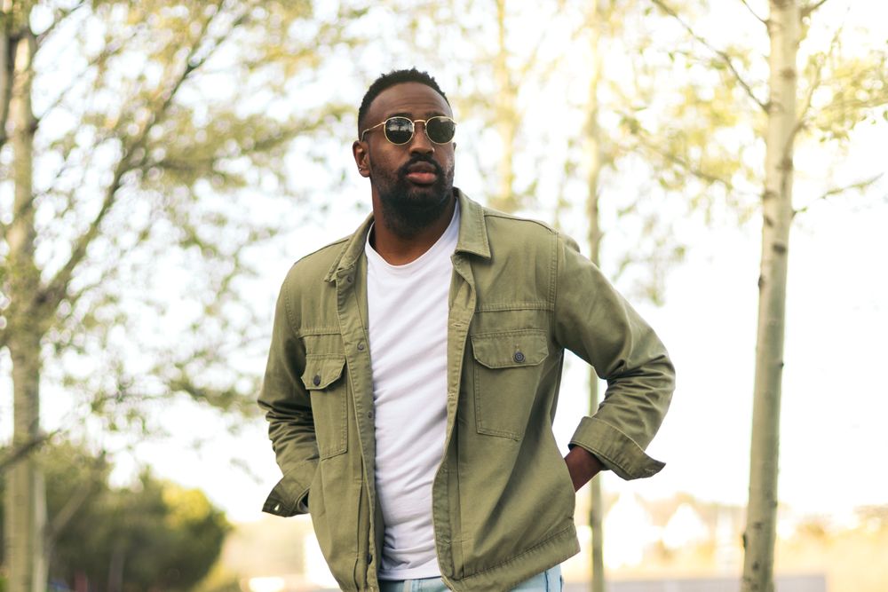 Black young man with sunglasses walking in a park