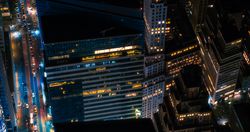 Scenic Aerial New York City View of Downtown Manhattan Architecture. Photo of Downtown Business District from a Helicopter. Cityscape with Buildings with Lights in Offices at Night