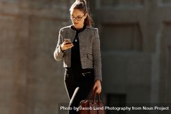 Businesswoman using mobile phone while commuting to office 5lVpMm