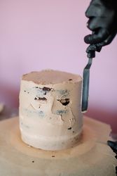 Person putting icing on round cake