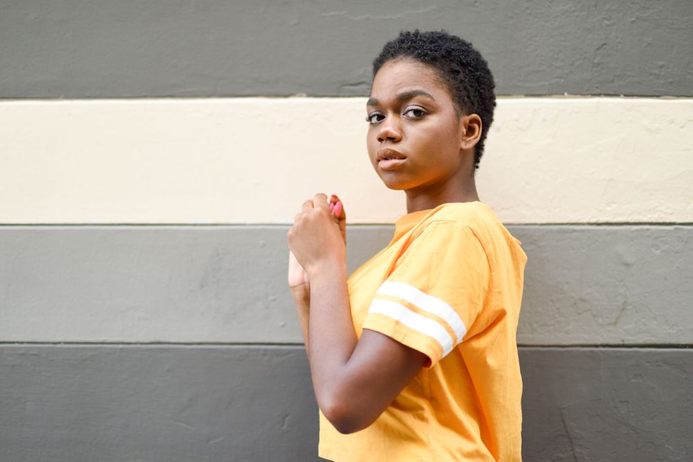 Black woman turning around in front of striped wall